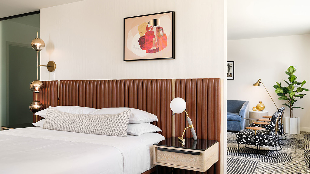 A bedroom with a bed and a chair.